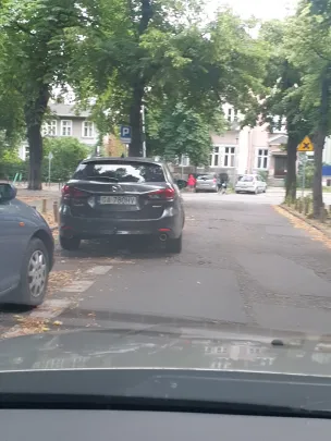 Połową samochodu na jezdni...