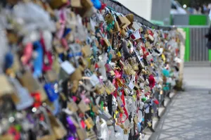 Rząd kłódek z imionami zakochanych na balustradzie Mostu Miłości w Paryżu.