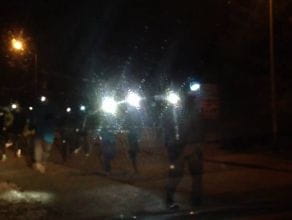 Grupa osób z latarkami na czołach biegnie przez Jasień