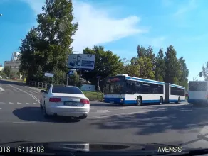 Dwa autobusy z pasażerami na czerwonym świetle