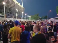 Kibice przez stadionem bawią się po golu