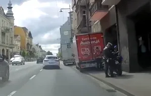 Policjant motocyklista spisuje niepoprawnie zaparkowane "dostawczaki"