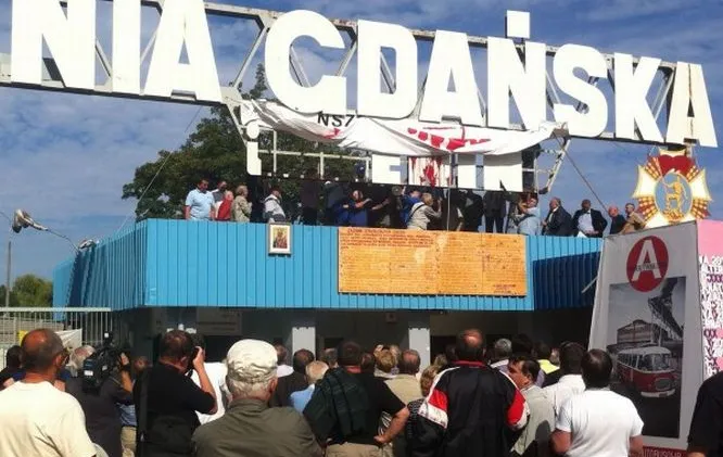 Związkowcy demontujący fragment szyldu znad stoczniowej bramy 28 sierpnia 2012 roku.