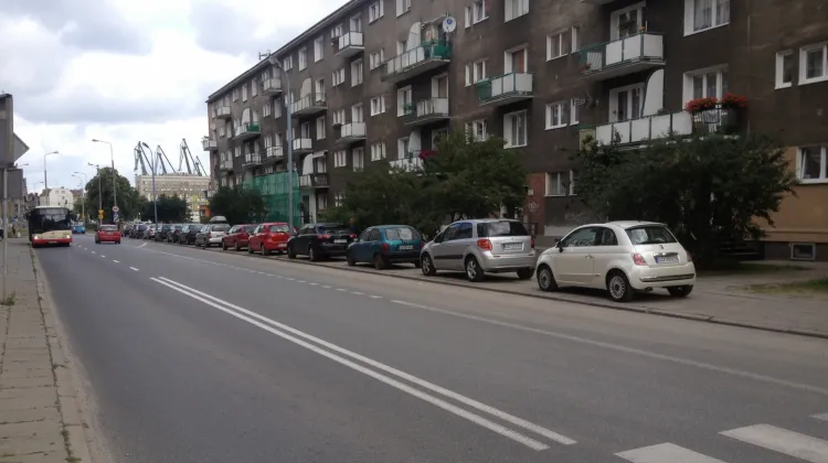 Ulica Łagiewniki w Gdańsku. Parkujące auta na chodniku.