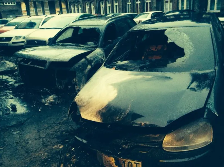 Spalone auta zaparkowane w podwórzu przy ul. Strzeleckiej.