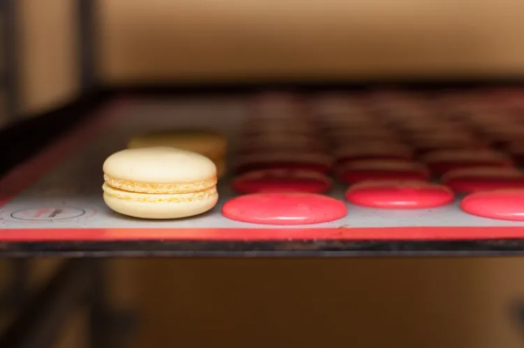 Gotowy macarons z masą cytrynową (ang. lemon custard) obok suszących się ciasteczek. 