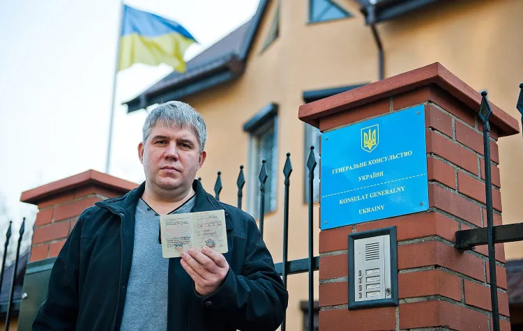 Viacheslav Shevchuk ze swoją książeczką wojskową przed konsulatem Ukrainy w Gdańsku.