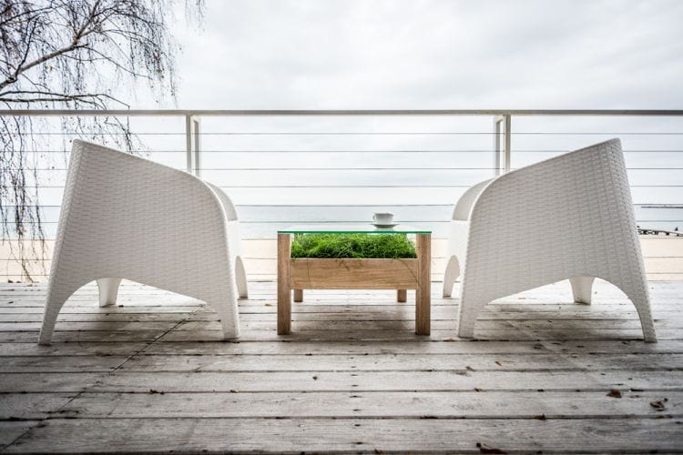 Wśród trendów w projektowaniu tarasów i balkonów od jakiegoś czasu utrzymuje się minimalizm - zestawienie bieli, zieleni i naturalnego drewna. W tendencję tę wpisuje bio stolik z wykorzystaniem kompozycji żywych roślin - propozycja Appo projekt.  