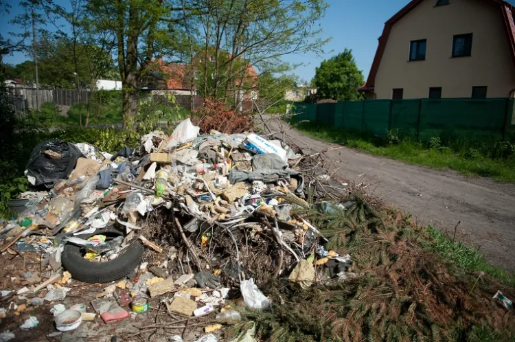 Mieszkańcy budynku (po prawej) od blisko pół roku walczą z władzami miasta o usunięcie legalnego, jak się okazuje, wysypiska śmieci.