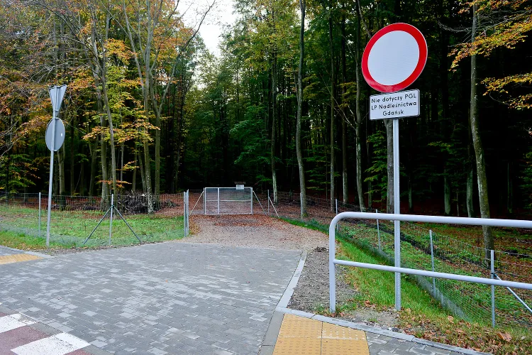 Zamknięta brama odcina dostęp do leśnej drogi, łączącej Karwiny i Chylonię.