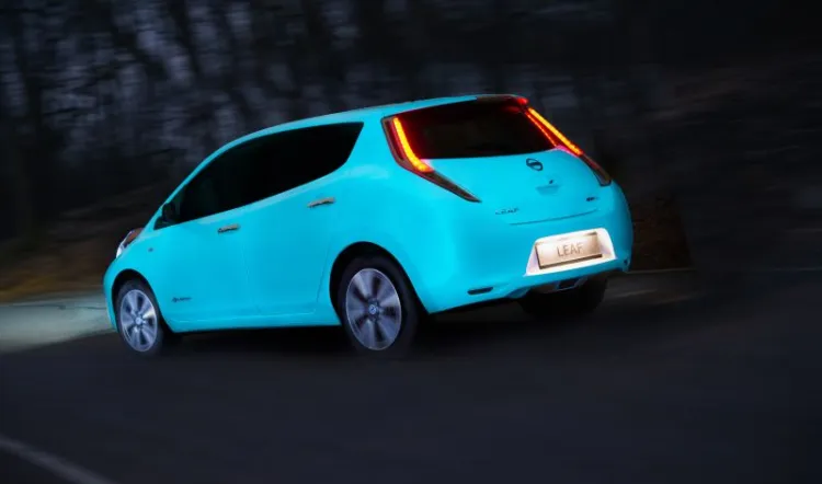 Elektryczny Nissan Leaf świeci w ciemności. To promocja odnawialnych źródeł energii. 