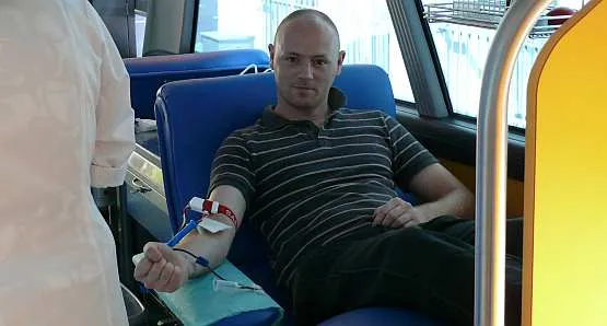 Oddawanie krwi w mobilnym punkcie jest szybie, łatwe i przyjemne. Nz. oddający krew policjant.