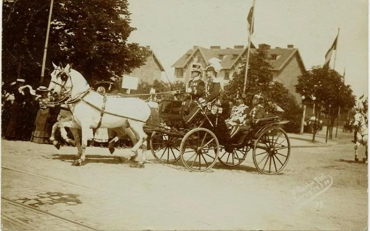 Dorożka z pruskimi oficerami wjeżdża w Grosse Alee (al. Zwycięstwa), w okolicach Bramy Oliwskiej. Drzewo widoczne po lewej stronie zdjęcia to już Park Steffensa. 