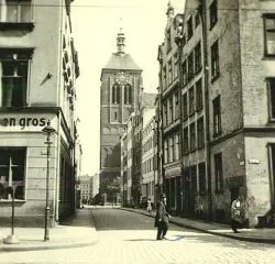 Ulica Tandeta widziana od strony ul. Szerokiej.  Na końcu ulicy widoczny kościół św. Jana. Zdjęcie pochodzi z początków XX w.