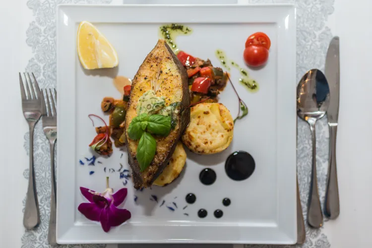 Halibut pieczony z dodatkiem kremowej zapiekanki ziemniaczanej oraz warzywnym ratatouille, aromatyzowanym świeżym tymiankiem. Zanim ryba trafi na talerz, wcześniej jest marynowana w zalewie sporządzonej ze świeżo wyciśniętego soku z cytryny i limonki w akompaniamencie miodu kwiatowego oraz oliwy z oliwek z pierwszego tłoczenia z lekką nutą świeżego rozmarynu i tymianku. Propozycja z karty menu restauracji Meridian Molo. 