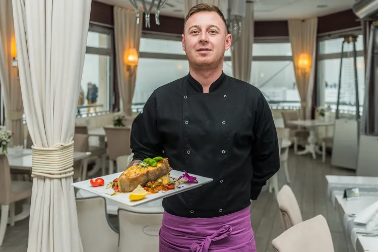 Szef kuchni restauracji Meridian Molo Przemysław Glesner prezentuje  danie z pieczonego halibuta. 