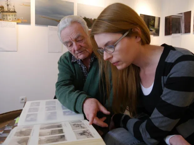 Mieszkający od sześćdziesięciu lat w Oliwie pan Roman Krzyżanowski prezentuje swoje fotografie koordynatorce projektu, Ewie Labenz z Fundacji Wspólnota Gdańska.