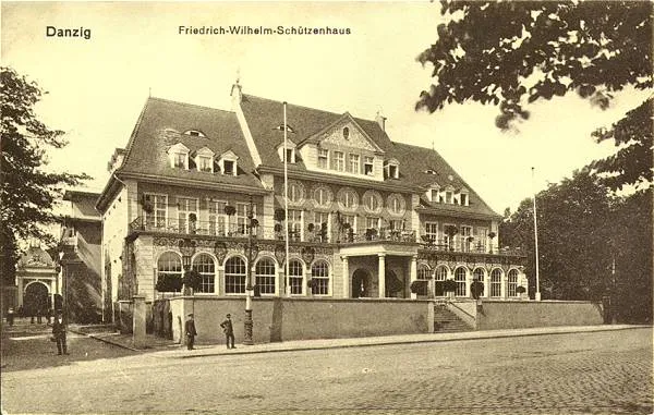 Dom strzelecki Fryderyka Wilhelma (niem. Friedrich-Wilhelm-Schützenhaus). To tutaj odbyło się spotkanie ze szwedzkim podróżnikiem Svenem Hedinem, który opowiadał słuchaczom o trwającym 8 lat pobycie w Azji Centralnej. Widoczny na zdjęciu budynek stał przy ul. 3 maja, został doszczętnie zniszczony pod koniec II wojny światowej.