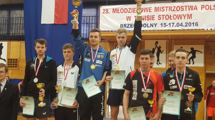 Dwaj tenisiści stołowi AZS AWFiS Gdańsk (biała bluza) na podium młodzieżowych mistrzostw Polski po turnieju drużynowym. Na jego najwyższym stopniu Marek Badowski, na niższym Damian Kreft.