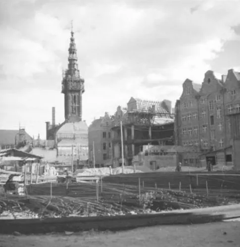 Gromadzenie materiałów do budowy kina. W głębi widoczna zachowana konstrukcja dawnego kina "Tobis-Palast", widok od ul. Lektykarskiej. Zdjęcie z 1951 r.