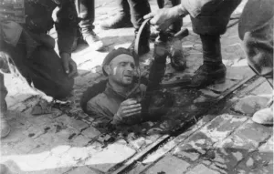 Powstaniec wyciągany z kanału przez żołnierzy niemieckich.