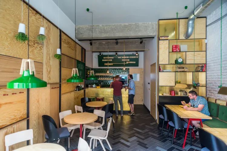 We wnętrzu baru Carmnik Kantyna dominuje sklejka, elementy mosiężne i zielony kolor.