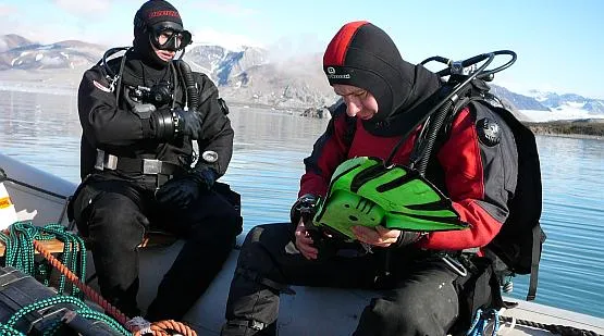 Przed nurkowaniem w lodowatej wodzie Piotr Kukliński (w czerwonym kombinezonie) zawsze dokładnie sprawdza sprzęt.
