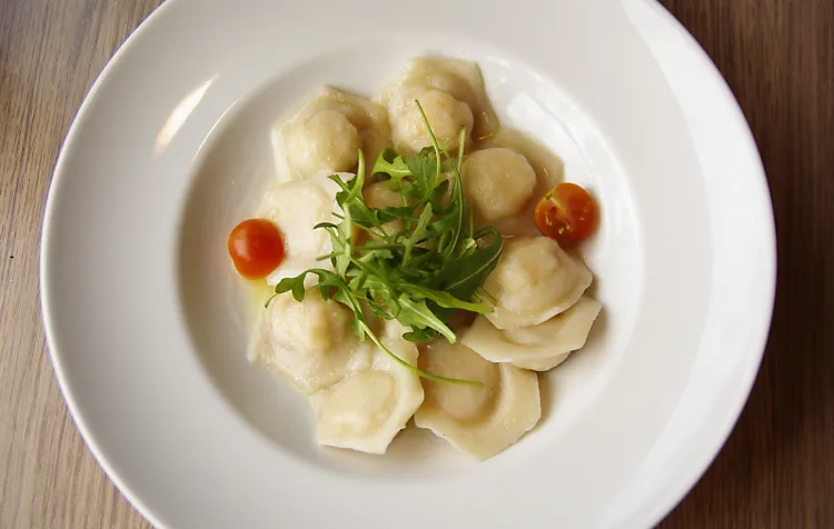 Ravioli con gamberi e salvia - domowe pierożki ravioli faszerowane krewetkami black tiger, szyjkami rakowymi, bekonem, marchewką i ricottą w delikatnym sosie maślano-cytrynowym.