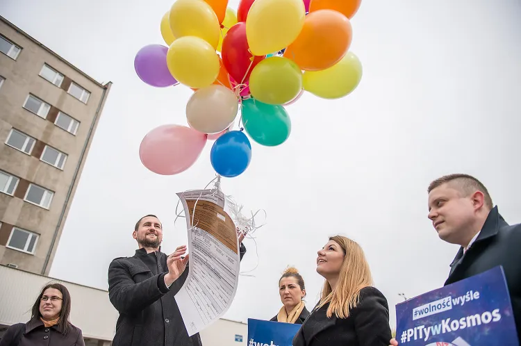 Przedstawiciele Wolności na znak protestu wysłali PIT-y w kosmos, a dokładniej podpięli wielkoformatowe kopie formularzy podatkowych pod baloniki z helem.

