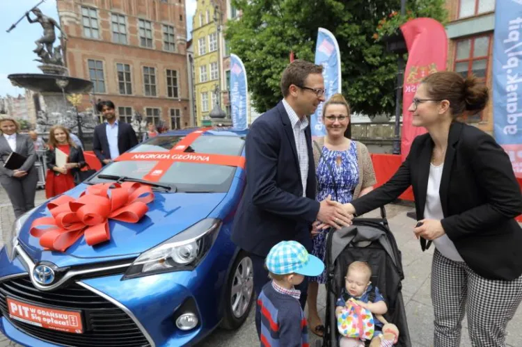 Michał Gad z rodziną odbiera kluczyki do samochodu z rąk Aleksandry Dulkiewicz, wiceprezydent Gdańska.