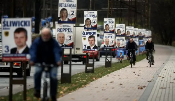Plakaty wyborcze wzdłuż al. Zwycięstwa w Gdyni. Kandydaci na radnych uśmiechają się i do kierowców, i do rowerzystów.