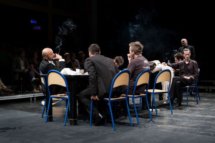 "Hamlet" Olivera Frljicia rozgrywa się przy stole, gdzie Hamlet (na krześle po prawej) sprzeciwiający się woli mającego charakter mafioza Klaudiusza (z papierosem po lewej) nie ma żadnych szans na przetrwanie. 