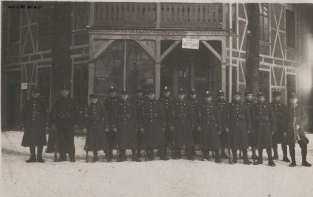 Polscy żołnierze stoją przed budynkiem Starych Koszar. Lata 30. XX wieku.