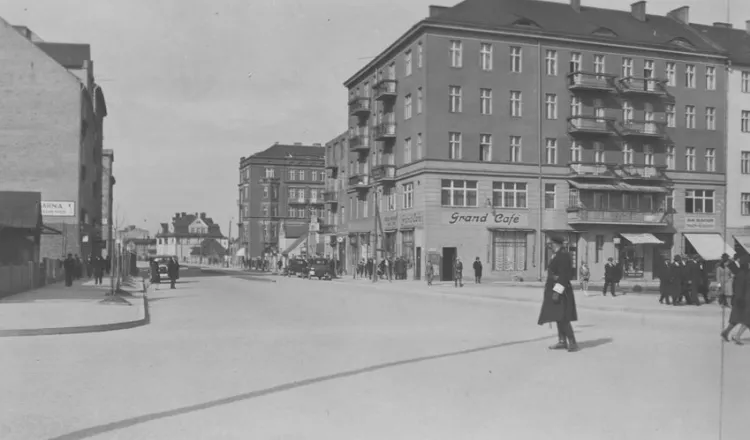 Policjant dyrygujący ruchem na ulicy Świętojańskiej w przedwojennej Gdyni. Widoczne samochody i kawiarnia Grand Cafe.