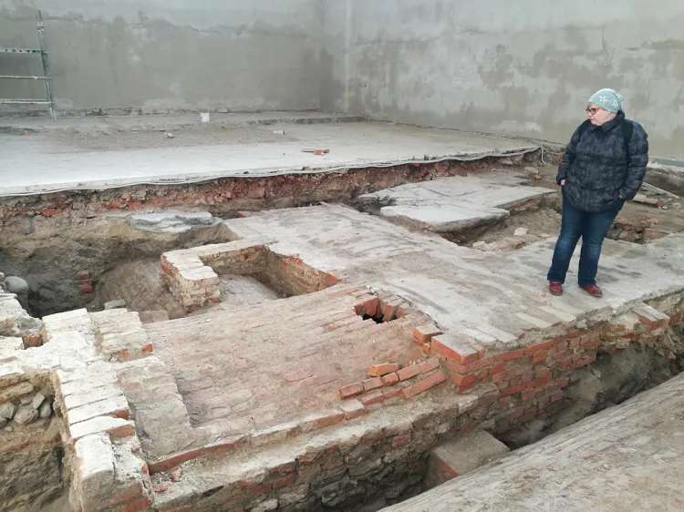 Archeolog Monika Kacprzak w prezbiterium kościoła św. Józefa w Gdańsku, na tle odkrytych krypt.