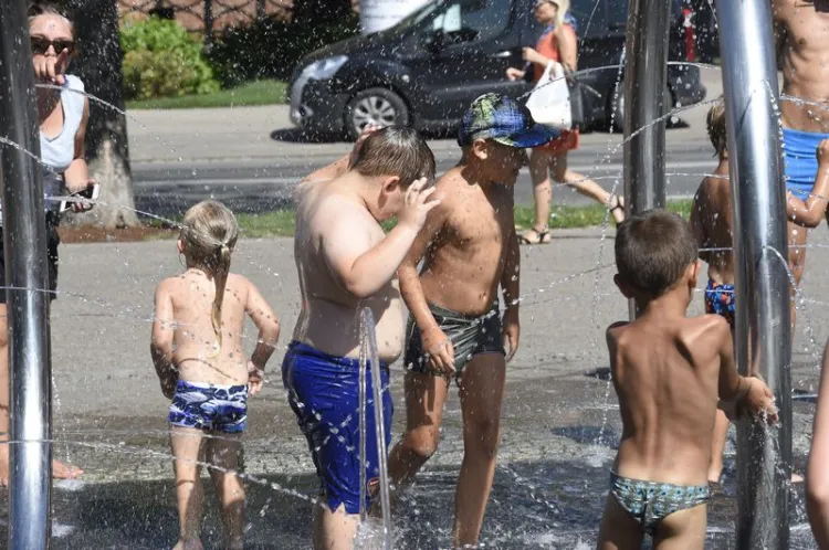 Dzieci radzą sobie z upałami pluskając się w miejskich fontannach.