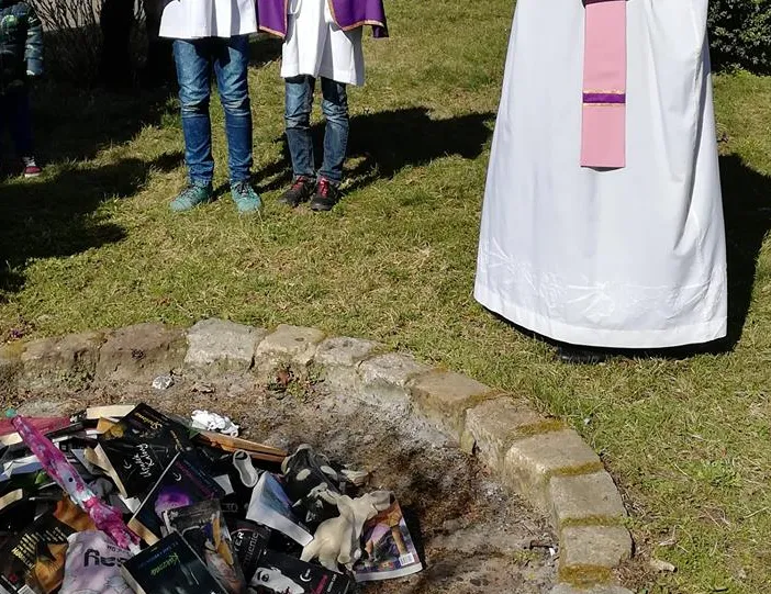 Kontrowersyjna akcja fundacji SMS z Nieba. Księża z ministrantami spalili w niedzielę książki przed kościołem w Gdańsku. 
