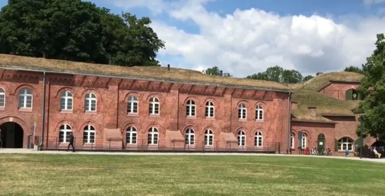 Główny plac na terenie Fortu Grodzisko. Nad dachami prowadzi ścieżka spacerowa. 