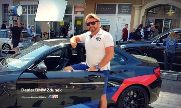 Michał Milowicz jest jednym z reżyserów nowej produkcji. Na zdjęciu pozuje przy BMW M2.