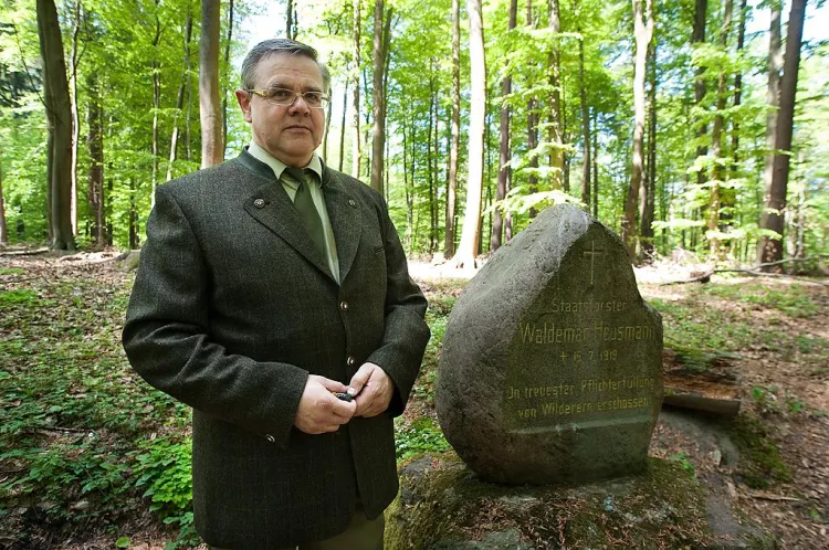 Leśniczy z Sopotu Waldemar Baranowski przy kamieniu upamiętniającym zbrodnię na jego koledze po fachu.
