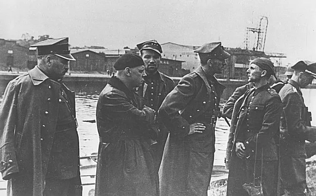 Polscy oficerowie po kapitulacji Westerplatte, 7 września 1939 r. Kapitan Franciszek Dąbrowski stoi czwarty od lewej, pochylony, z ręką opartą na biodrze.