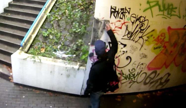 Kamery monitoringu uchwyciły moment, w którym 40-latek z Gdyni zaczął malować ścianę.