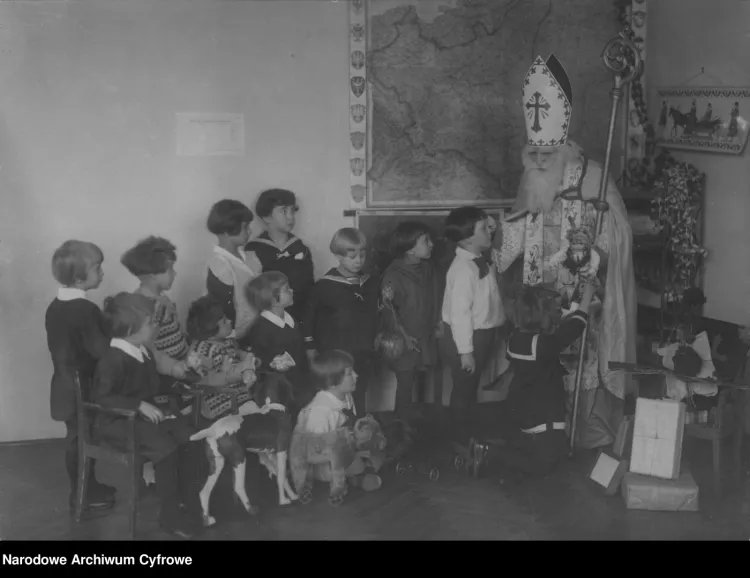 Święty Mikołaj wręczający prezenty dzieciom na gwiazdkę 1925 roku. 