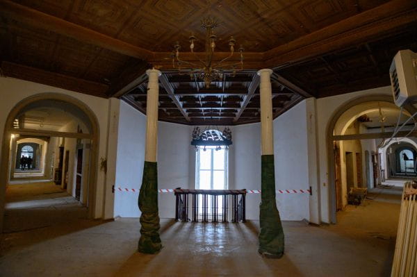 Żeliwne kolumny i drewniany, kasetonowy sufit - zachowane historyczne elementy wewnątrz budynku dawnej dyrekcji Stoczni Cesarskiej.