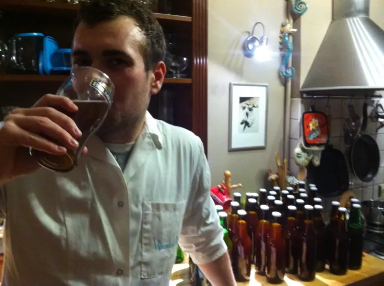 Tomasz Brzostowski degustuje pierwsze uwarzone przez siebie piwo. 