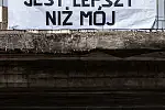 Transparent z napisem "Twój ból jest lepszy niż mój" na kładce dla pieszych nad aleją Jana Pawła II w Gdańsk.