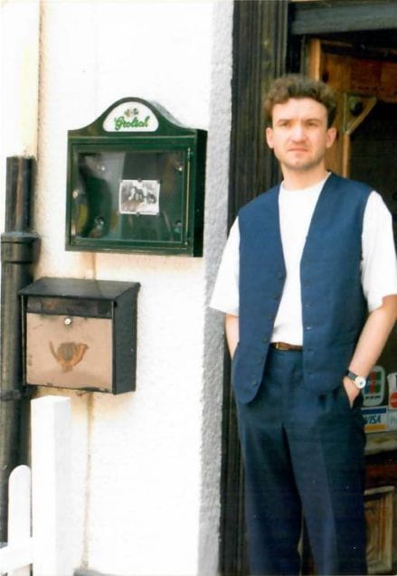 Dariusz Knyszyński, pierwszy barman Błękitnego Pudla. Zdjęcie na tle wejścia do lokalu, początek drugiej połowy lat 90.