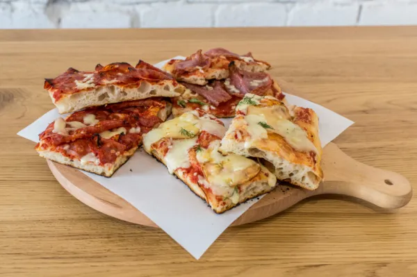 Pizzę rzymską, serwowaną na kawałki, zjemy m.in. w gdańskim 01 Pizzarium.

