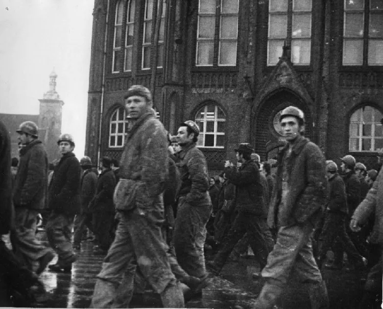 Robotnicy wracający do Stoczni Gdańskiej im. Lenina po pierwszych protestach pod Komitetem Wojewódzkim PZPR, w tle kościół św. Jakuba i I Liceum Ogólnokształcące. 14 grudnia 1970 r.