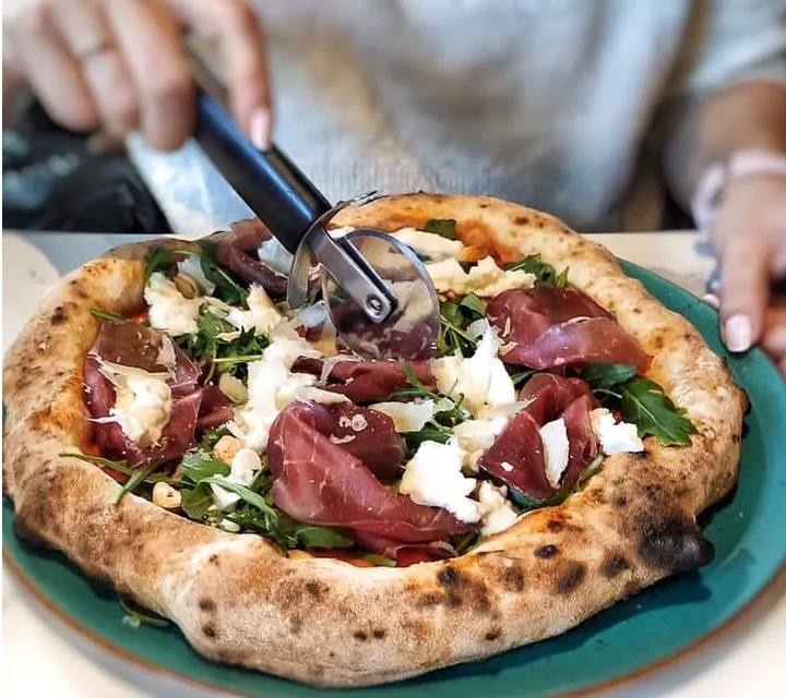 Pizzę neapolitańską najlepiej podzielić na cztery kawałki, a następnie jeść sztućcami, zaczynając od jej cienkiego środka.